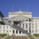 Stormont parliament buildings with a pair of giant scissors in the foreground.