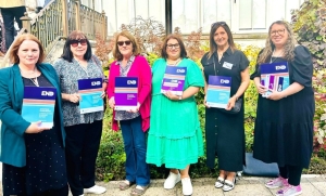 A group of women holding reports.
